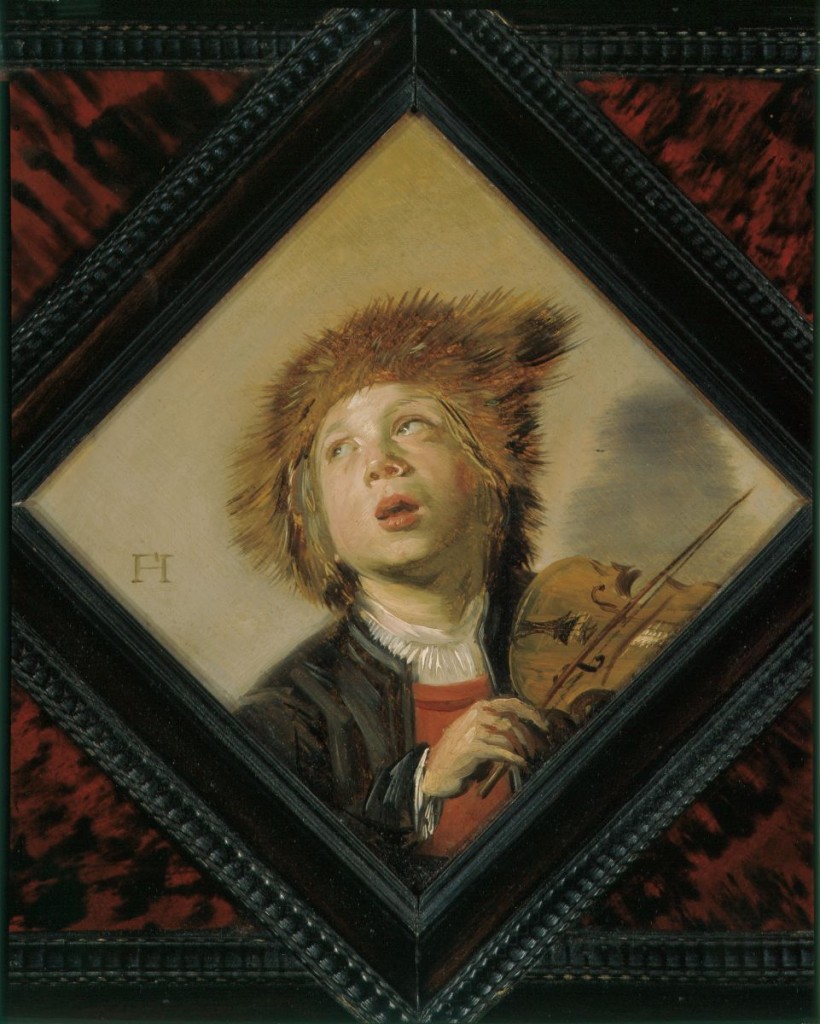 Portrait of a boy wearing a fur hat playing a violin.