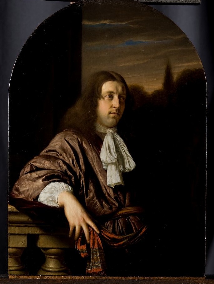 Portrait of a man with long brown hair leaning against a railing.