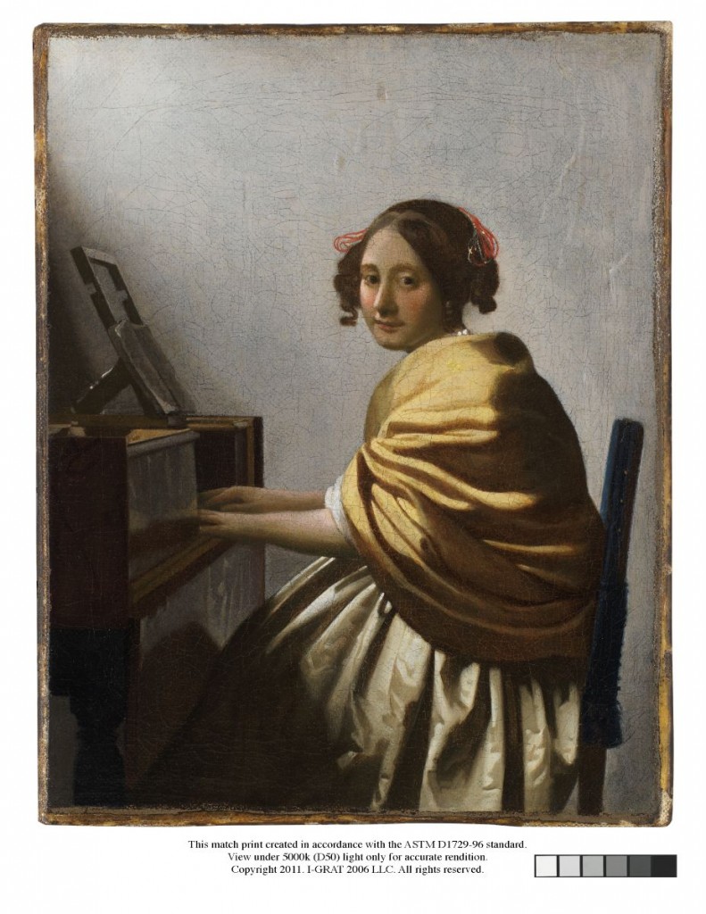 A girl sitting at a Virginal. She has curly hair and wears a yellow shawl.