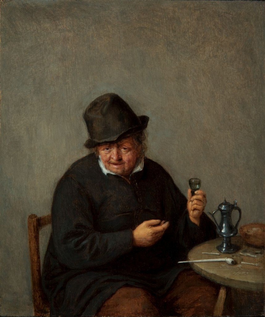 Portrait of an older person sitting at a table, wearing all black.