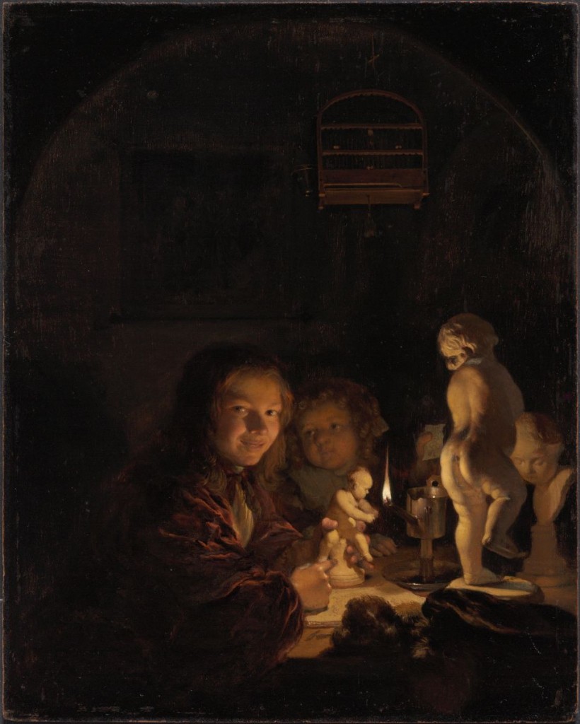 2 children sit at a table, illuminated by a candle. On the table are a series of white statuettes.